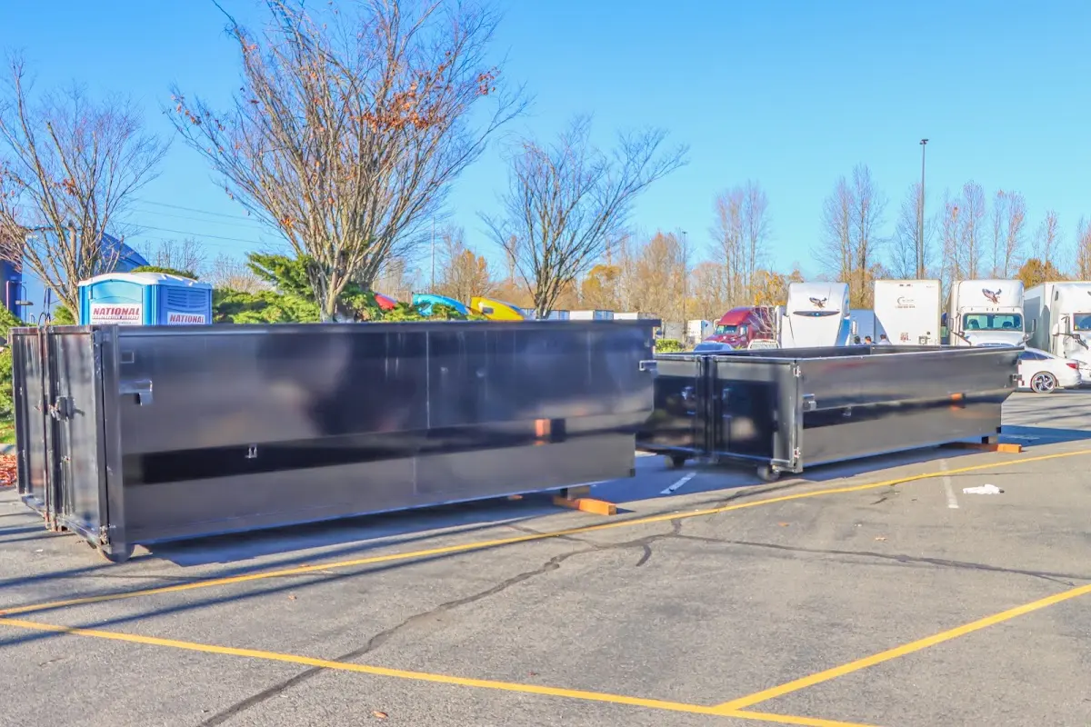 Professional dumpster rental service with roll-off container on residential driveway in Robinwood